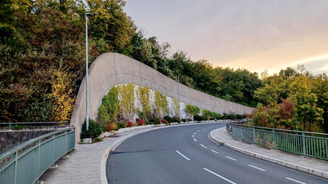 B27 in den Morgenstunden, malerische Kurve Bergauffahrt mit herbstlichen Laubfarben.