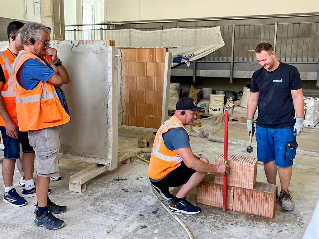 In der Werkshalle, Baustoff-Versuchsaufbau, Baustoffe im Lot mit Werksmitarbeiter maxit