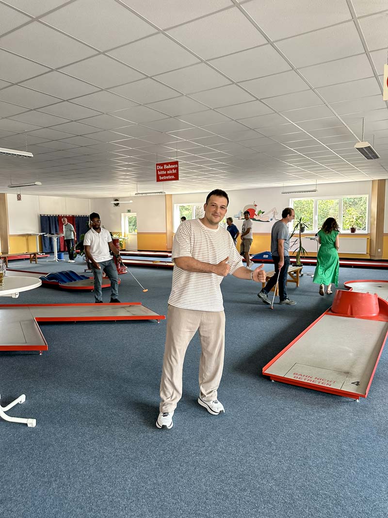Indoor Minigolfanlage, Teamevent: Einer der Ingenieure freut sich, beide Daumen hoch.