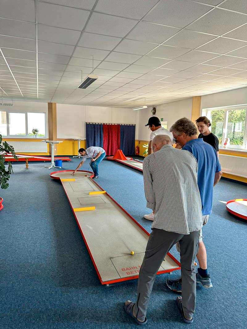 Indoor Minigolfanlage, Teamevent Confido Ingenieure, gegenseitige Unterstützung am Abschlag.